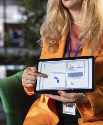 Diverse business leaders in a meeting sharing ideas for corporate growth, analyzing infographics for a monthly report task. Powerful women working together to ensure business success, productivity.